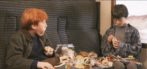 ハリーポッターと賢者の石の汽車の中でお菓子を食べるハリーとロン